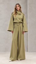 Front full-length view of model wearing sage green double-breasted wide-leg trench jumpsuit