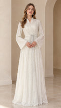 Front view of model wearing white sequined long sleeve maxi evening dress with belted waist
