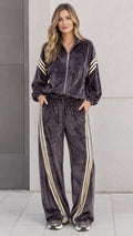 Full front view of model wearing charcoal grey velour tracksuit set with zip jacket and striped wide leg pants