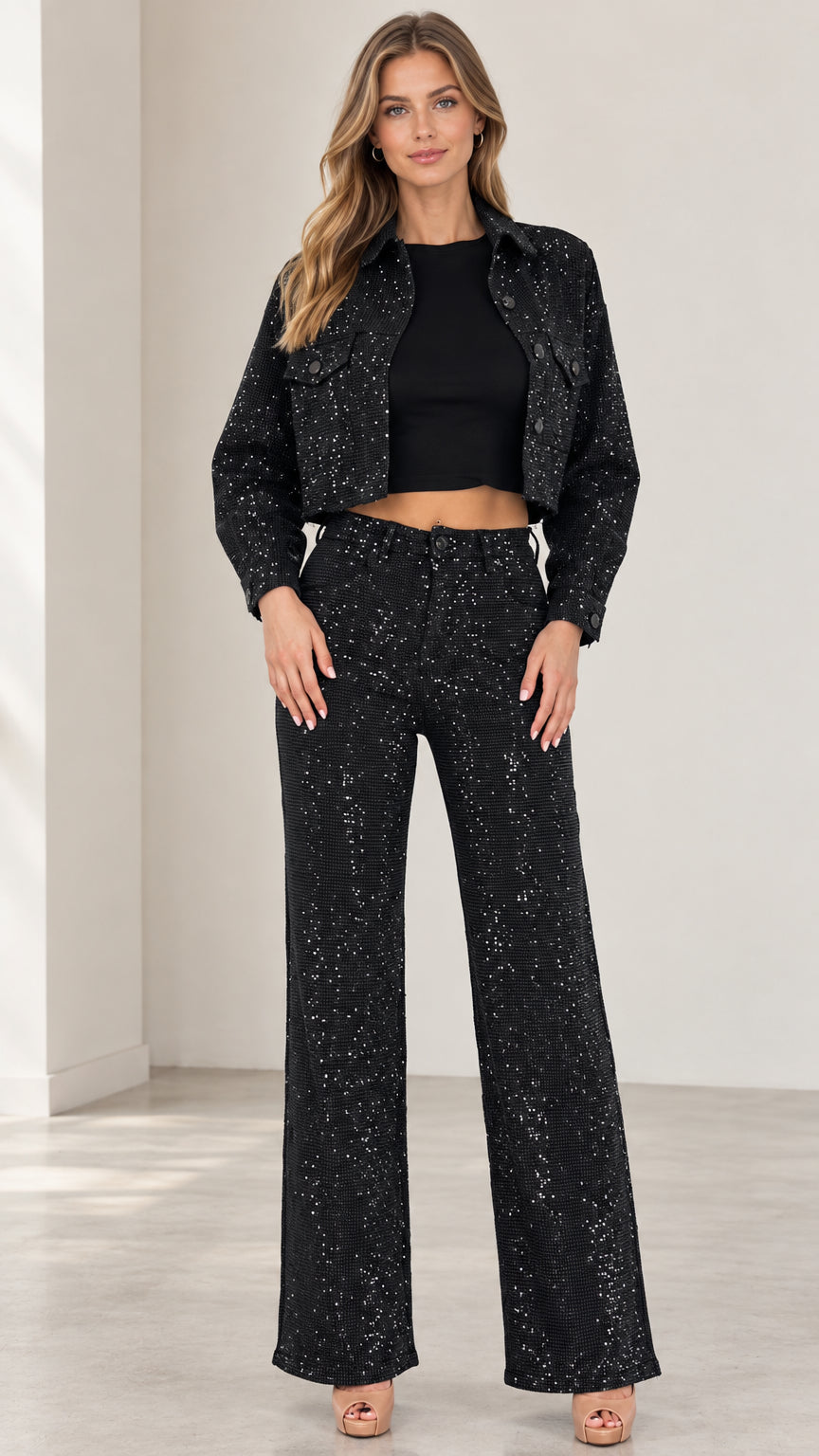 Front full-length view of woman wearing black sparkle cropped jacket and wide-leg trousers set