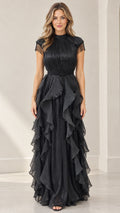 Front full-length view of woman wearing black pleated tiered ruffle evening maxi dress with beaded fringe cap sleeves