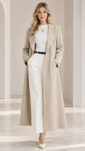 Front view of model wearing a beige tailored maxi trench coat styled with white top and wide-leg trousers