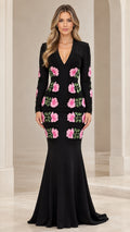 Front view of black long sleeve mermaid evening gown with pink floral applique details