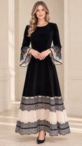 Front view of model wearing black velvet maxi dress with tiered lace hem and bell sleeves