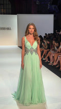 Mint green pleated floor-length evening gown with a deep V-neck and embellished waist, front view