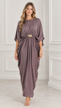 Front view of model wearing a mauve draped kaftan maxi dress with gold buckle accent