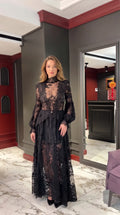 Front view of woman wearing Black floral lace high-neck maxi dress with long bishop sleeves