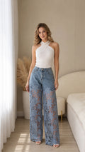 Full front view of model wearing denim blue high-waisted jeans with sheer floral lace legs