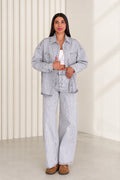 Front view of model wearing light blue striped denim shirt jacket and wide leg pants set