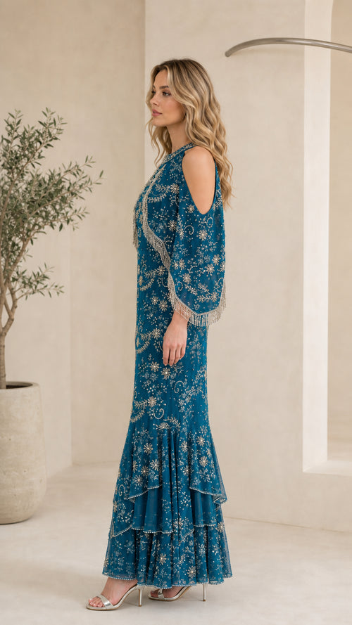 Side profile of model in Teal Blue beaded fringe capelet gown showing silhouette