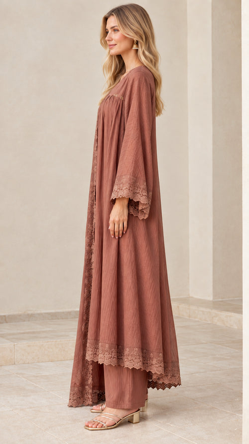 Side profile of model in dusty rose crinkle tunic, wide-leg trousers, and duster set