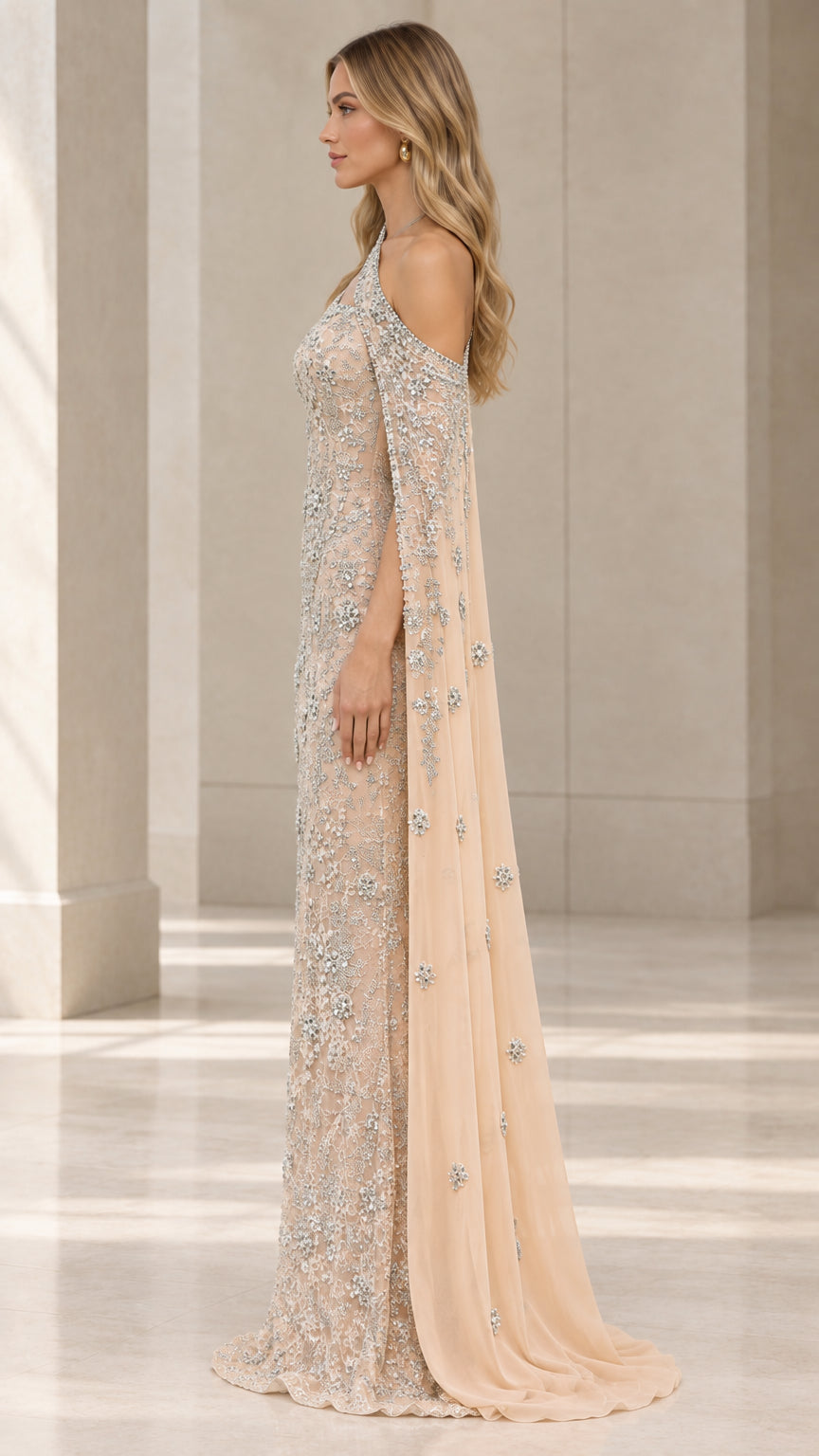 Side profile view of champagne crystal-embroidered formal gown showcasing shoulder cape drape