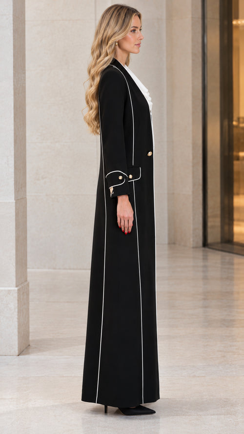 Side profile view of black longline maxi coat showing vertical white trim and tailored fit