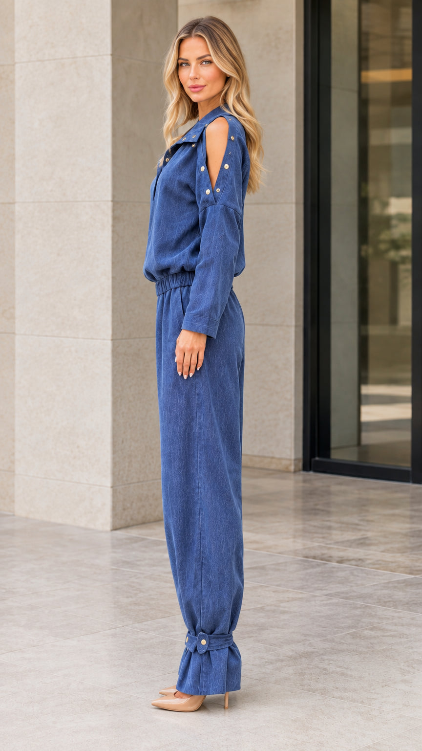 Side profile of model wearing Denim Blue long sleeve jumpsuit with cinched ankles