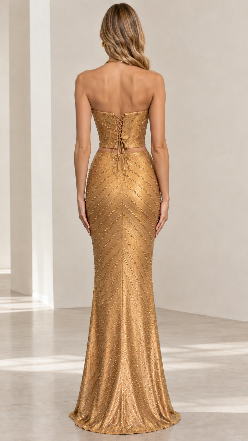 Back view of gold two-piece gown showing lace-up corset detail