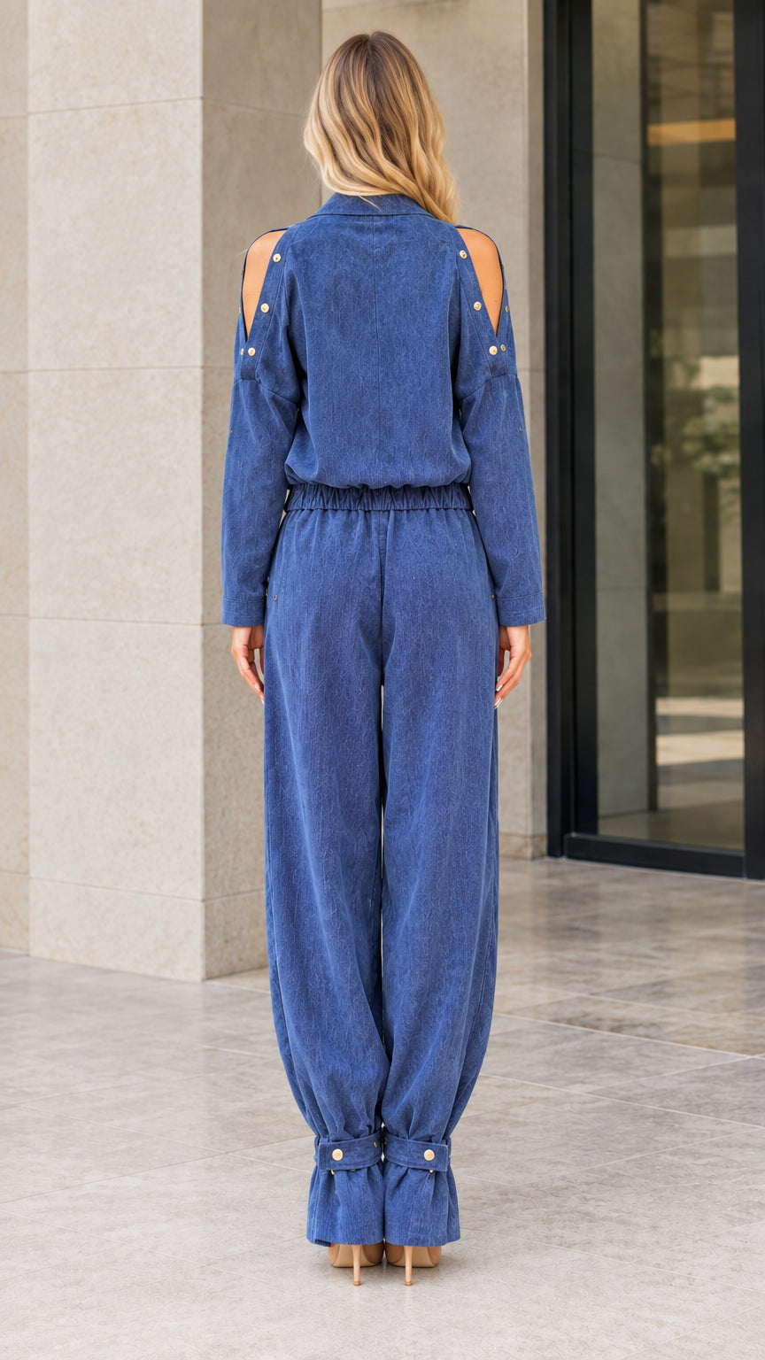 Back view of model wearing Denim Blue cold shoulder jumpsuit with elastic waist