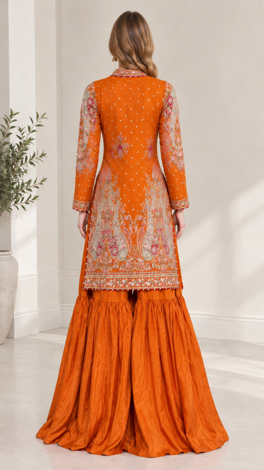 Back view of woman showcasing the embroidered longline jacket in Rust Orange