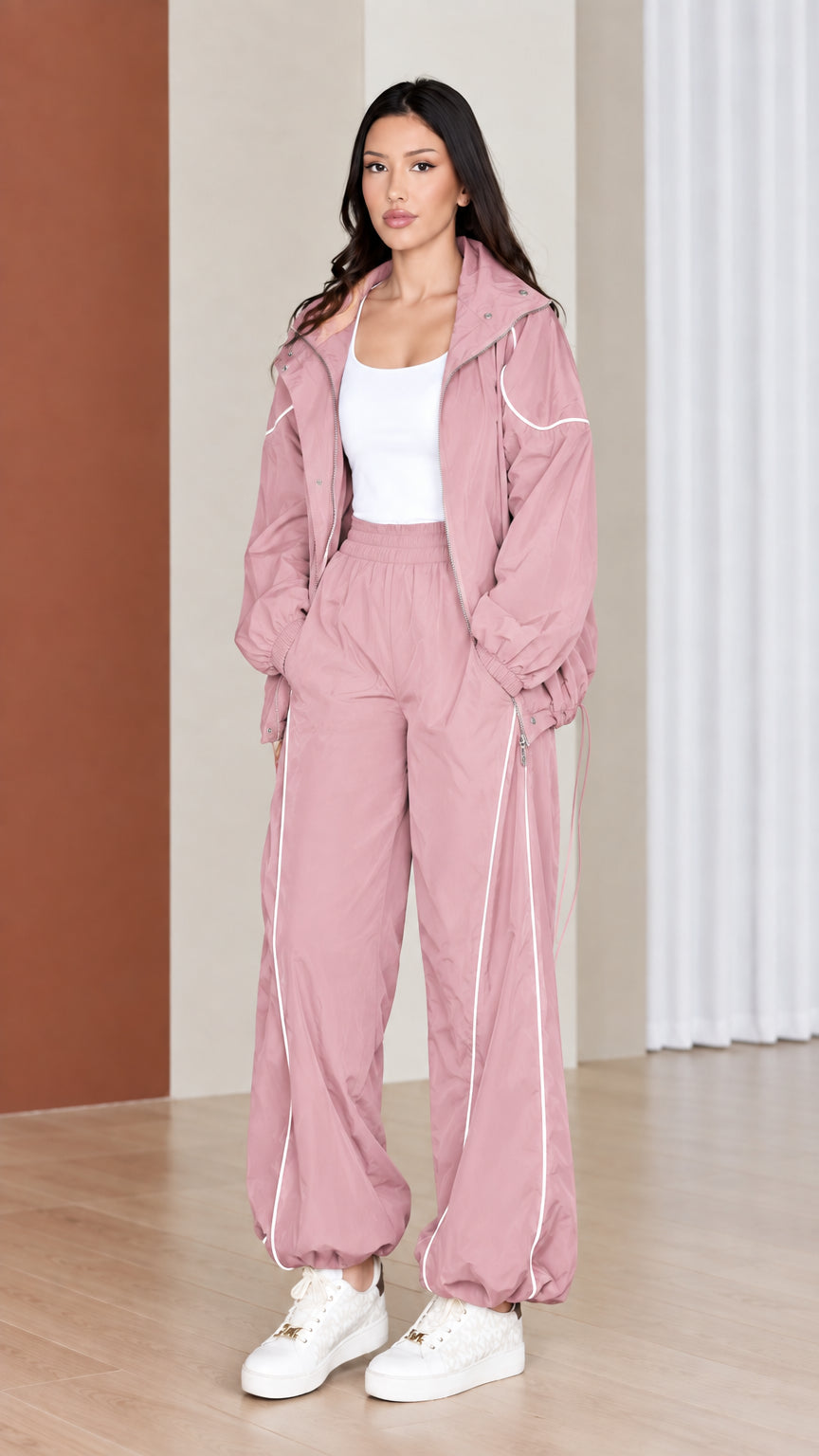 Full-length view of woman wearing soft dusty pink windbreaker tracksuit set